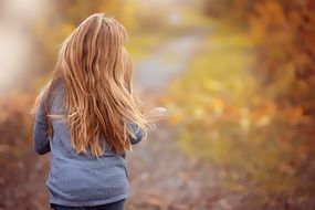 Girl with Long Hair Runs away at Autumn