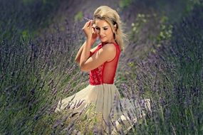 Blonde woman in white and red dress in the beautiful lavender field