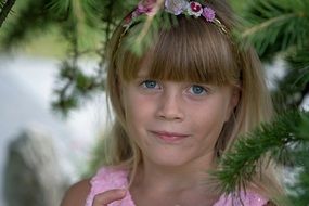 portrait of girl among the Christmas tree branches