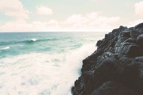 black cliff and white foam of the ocean