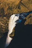 waterfall from a cliff on a background of autumn trees