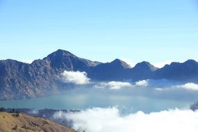 white clouds over a volcano in indonesia