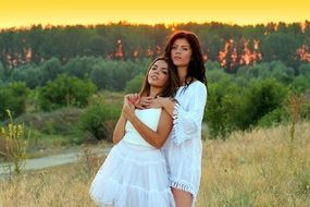 girls in white dresses at sunset