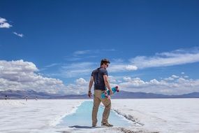 young man with a skateboard on salt marshes in argentina