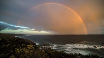 rainbow on the coast under dark clouds