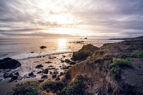 sunset over a hillside on the ocean