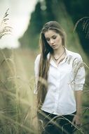 portrait of a beautiful girl among tall grass