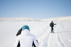 tourists on a snowy road on beautiful white landscape