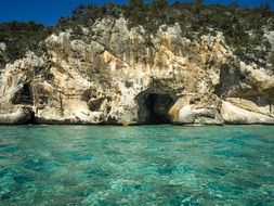 rocky coast and transparent sea water in cala gonone