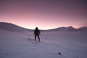 hiker in the snowy mountains at dusk