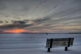 wooden bench on the shore of a frozen pigeon lake in Ð¡anada