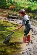 boy catching a fish in the river