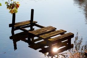 Old wooden small bridge on a lake