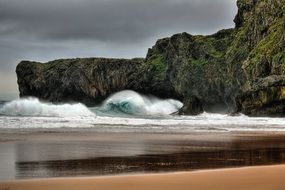waves beat against the rocks on the shore