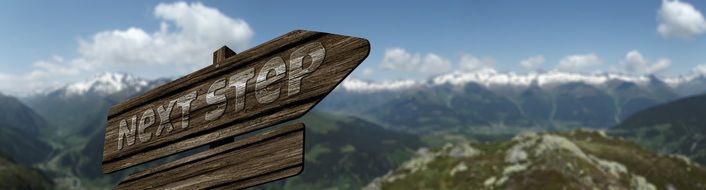 wooden signpost for the next step in the mountains