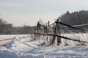 wooden fence on a field with snow