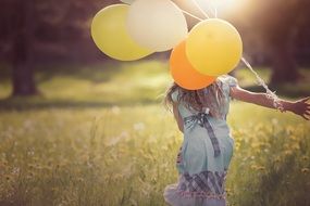 girl with balloons in the sunlight