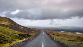 cloudy sky over a road along the coast