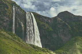 landscape with a waterfall on a high cliff