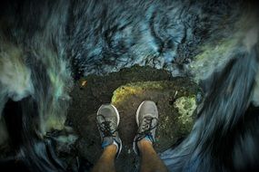A man stands on a stone in a whirlpool