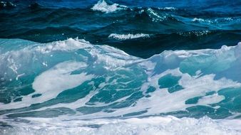 blue ocean waves with white foam