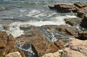 foam on the water near the rock