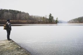 man by the shore of a frozen lake