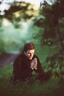 man praying in the woods