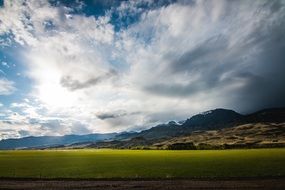 photo of feather clouds over a green field