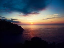 colorful sunset over the dark ocean coast