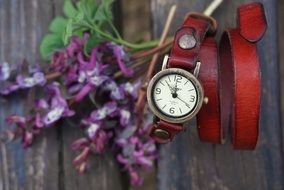 bouquet of lilacs and a wristwatch on a park bench