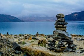 tower of stones on the coast of the lake