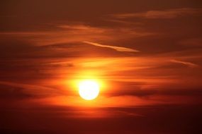 bright orange setting sun in the evening sky