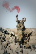 military with a red smoke bomb