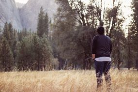 young man looks into the distance standing on the field