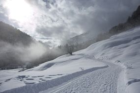 landscape of road in a snowy valley on alps