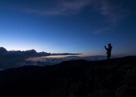 silhouette of a photographer in the mountains at sunset