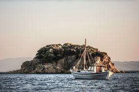 boat in the sea on the background of a rocky island