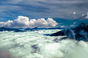 white clouds above the peaks of the Alps