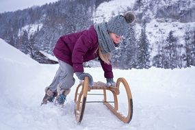 child with a sled on a snowy day