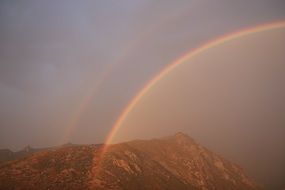 double Rainbow in Sky above mountain summit