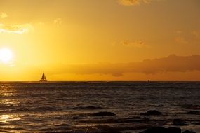 sailing boat at yellow sunset in hawaii