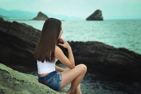 long-haired girl in shorts on the beach