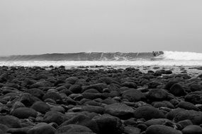 black and white picture of a surfer on ocean waves