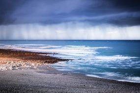 distant rain in colorful seascape, france, Normandy, Etretat