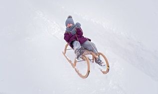child is riding on a sleigh