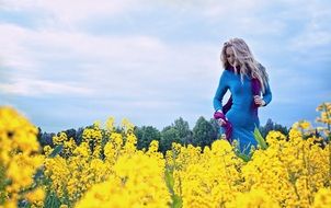 blonde on a field of wild yellow flowers