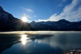 bright sun over a mountain lake