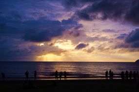 people on the beach in malaysia at dusk