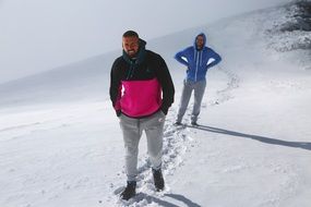 people stand in the snow on the mountain